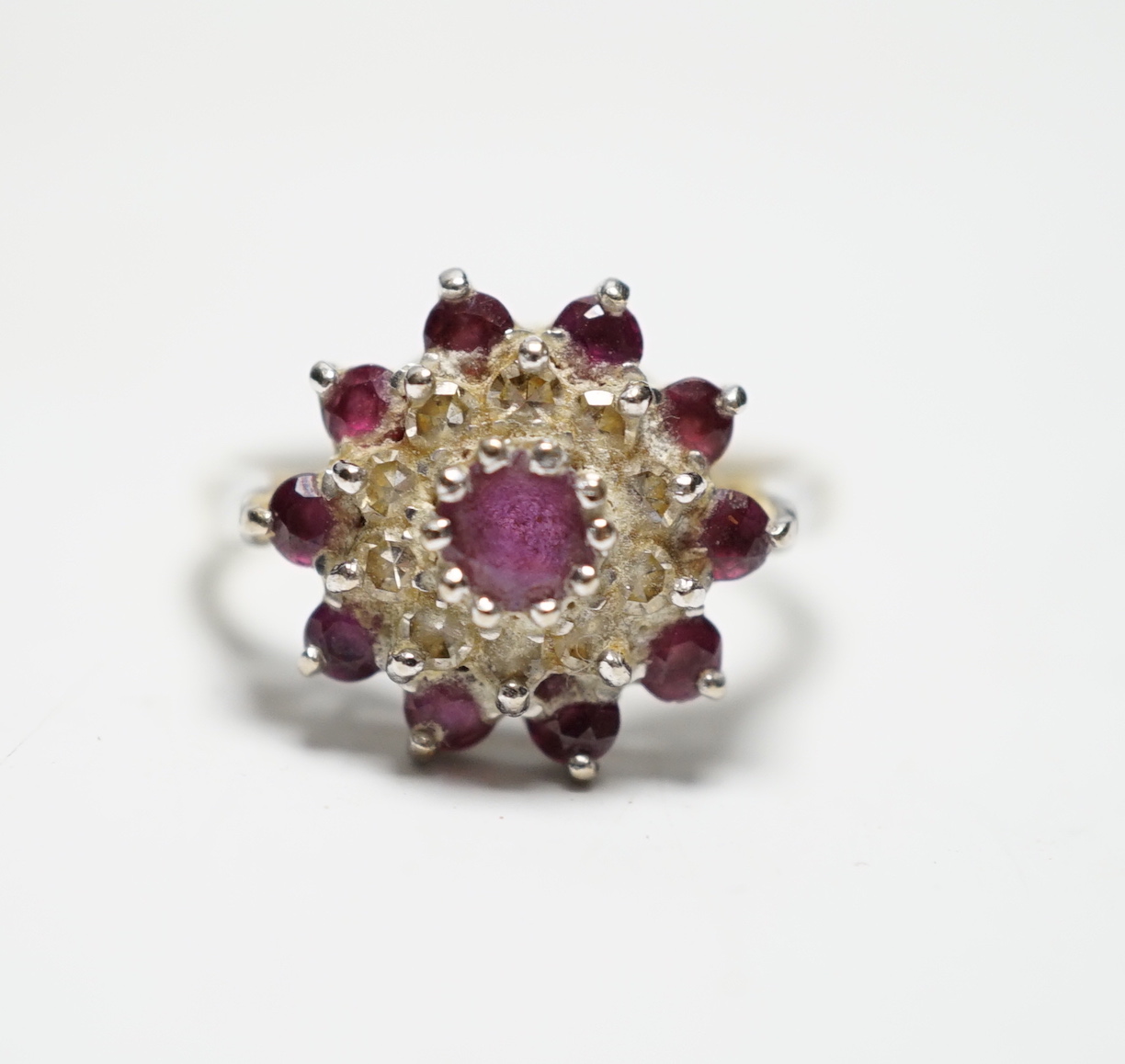 A modern 18ct gold, ruby and diamond set flowerhead cluster ring, size O, gross weight 5.2 grams.